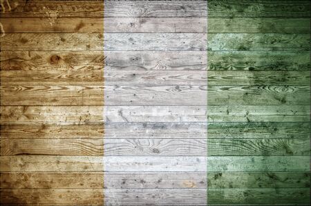 A vignetted background image of the flag of Ivory Coast painted onto wooden boards of a wall or floor.の写真素材