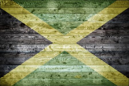 A vignetted background image of the flag of Jamaica painted onto wooden boards of a wall or floor.の写真素材