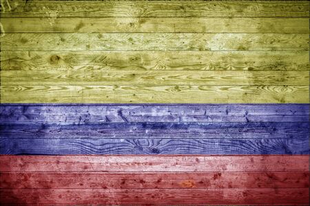 A vignetted background image of the flag of Colombia painted onto wooden boards of a wall or floor.の写真素材
