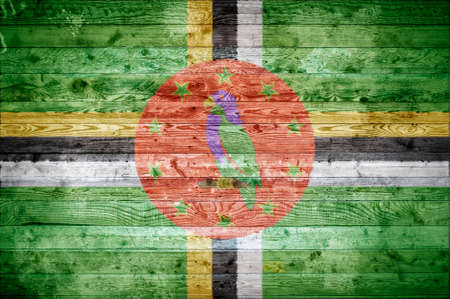 A vignetted background image of the flag of Dominica painted onto wooden boards of a wall or floor.の写真素材