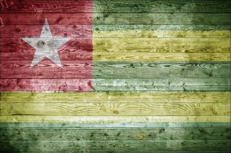 A vignetted background image of the flag of Togo onto wooden boards of a wall or floor.の写真素材