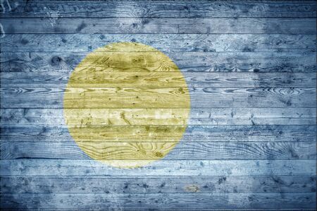 A vignetted background image of the flag of Palau onto wooden boards of a wall or floor.の写真素材