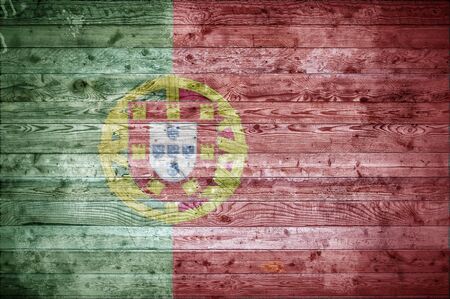 A vignetted background image of the flag of Portugal onto wooden boards of a wall or floor.の写真素材