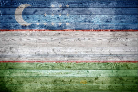A vignetted background image of the flag of Uzbekistan onto wooden boards of a wall or floor.の写真素材