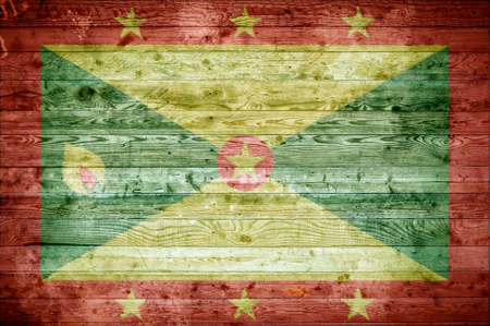 A vignetted background image of the flag of Grenada painted onto wooden boards of a wall or floor.の写真素材