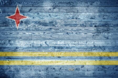 A vignetted background image of the flag of Aruba painted onto wooden boards of a wall or floor.の写真素材