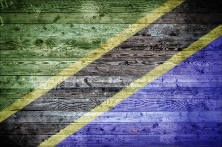A vignetted background image of the flag of Tanzania onto wooden boards of a wall or floor.の写真素材