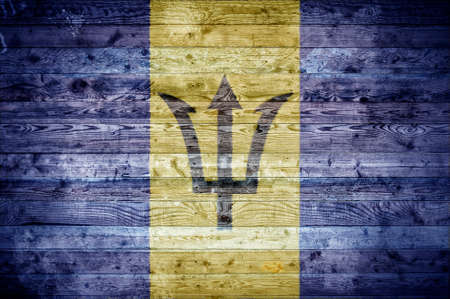 A vignetted background image of the flag of Barbados painted onto wooden boards of a wall or floor.の写真素材