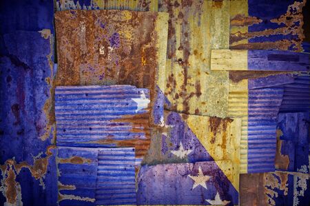 An abstract background image of the flag of Bosnia and Herzegovina painted on to rusty corrugated iron sheets overlapping to form a wall or fence.の写真素材