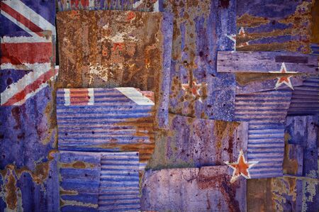 An abstract background image of the flag of New Zealand painted on to rusty corrugated iron sheets overlapping to form a wall or fence.の写真素材