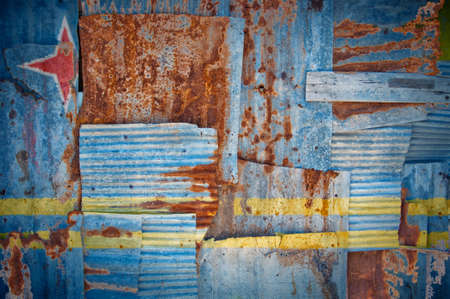 An abstract background image of the flag of Aruba painted on to rusty corrugated iron sheets...