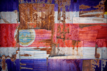 An abstract background image of the flag of Costa Rica painted on to rusty corrugated iron sheets overlapping to form a wall or fence.の写真素材