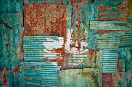 An abstract background image of the flag of Macau painted on to rusty corrugated iron sheets overlapping to form a wall or fence.の写真素材