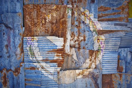 An abstract background image of the flag of Northern Marianas painted on to rusty corrugated iron sheets overlapping to form a wall or fence.の写真素材