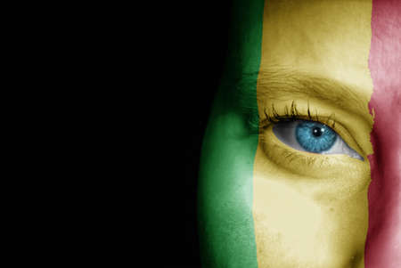 A young female with the flag of Mali painted on her face on her way to a sporting event to show her support.の写真素材