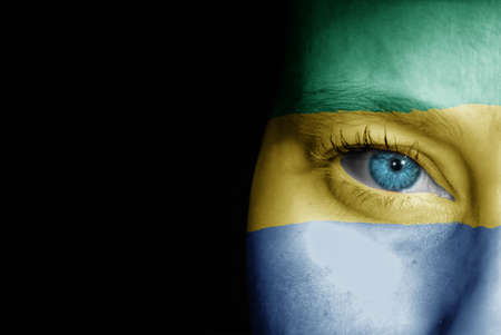 A young female with the flag of Gabon painted on her face on her way to a sporting event to show her support.の写真素材