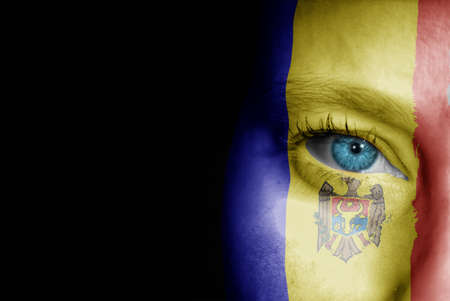A young female with the flag of Moldova painted on her face on her way to a sporting event to show her support.の写真素材