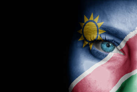 A young female with the flag of Namibia painted on her face on her way to a sporting event to show her support.の写真素材