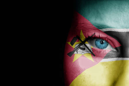 A young female with the flag of Mozambique painted on her face on her way to a sporting event to show her support.の写真素材