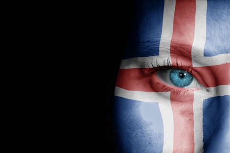 A young female with the flag of Iceland painted on her face on her way to a sporting event to show her support.の写真素材