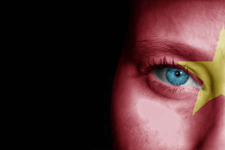 A young female with the flag of Vietnam painted on her face on her way to a sporting event to show her support.の写真素材