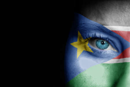 A young female with the flag of South Sudan painted on her face on her way to a sporting event to show her support.の写真素材