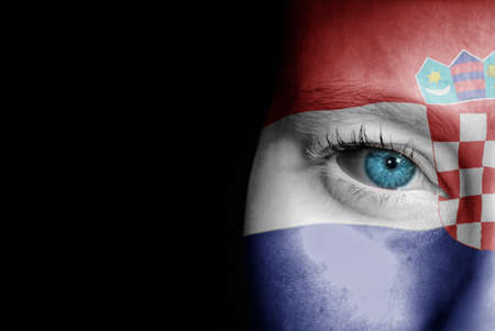 A young female with the flag of Croatia painted on her face on her way to a sporting event to show her support.の写真素材