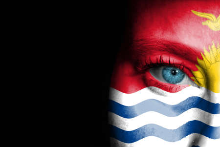 A young female with the flag of Kiribati painted on her face on her way to a sporting event to show her support.の写真素材
