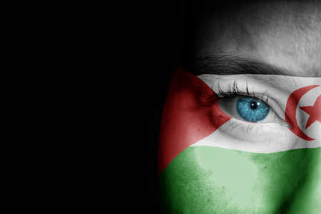 A young female with the flag of Western Sahara painted on her face on her way to a sporting event to show her support.の写真素材