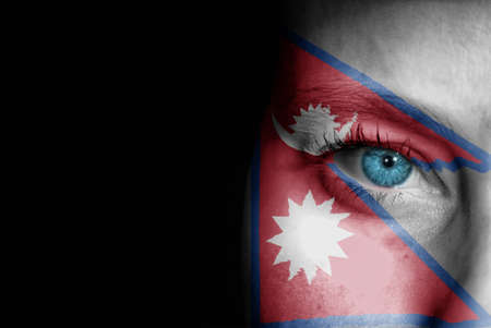 A young female with the flag of Nepal painted on her face on her way to a sporting event to show her support.の写真素材