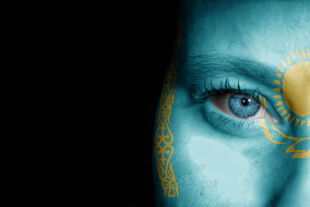 A young female with the flag of Kazakhstan painted on her face on her way to a sporting event to show her support.の写真素材