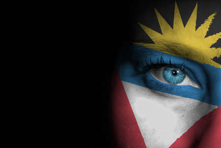 A young female with the flag of Antigua and Barbuda painted on her face on her way to a sporting event to show her support.の写真素材