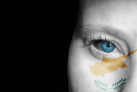 A young female with the flag of Cyprus painted on her face on her way to a sporting event to show her support.の写真素材