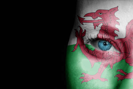 A young female with the flag of Wales painted on her face on her way to a sporting event to show her support.の写真素材