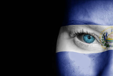 A young female with the flag of El Salvador painted on her face on her way to a sporting event to show her support.の写真素材