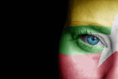 A young female with the flag of Myanmar painted on her face on her way to a sporting event to show her support.の写真素材