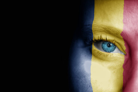 A young female with the flag of Chad painted on her face on her way to a sporting event to show her support.の写真素材