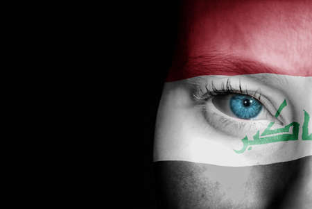 A young female with the flag of Iraq painted on her face on her way to a sporting event to show her support.の写真素材