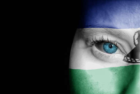 A young female with the flag of Lesotho painted on her face on her way to a sporting event to show her support.の写真素材