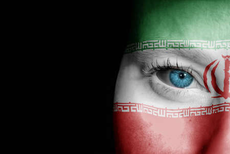 A young female with the flag of Iran painted on her face on her way to a sporting event to show her support.の写真素材