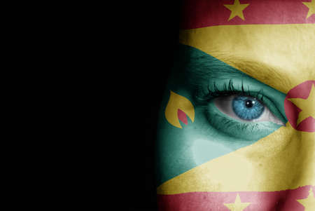 A young female with the flag of Grenada painted on her face on her way to a sporting event to show her support.の写真素材