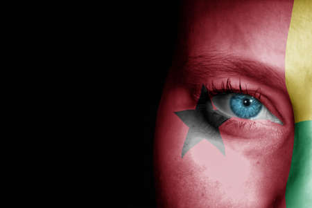 A young female with the flag of Guinea Bissau painted on her face on her way to a sporting event to show her support.の写真素材