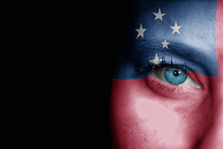 A young female with the flag of Samoa painted on her face on her way to a sporting event to show her support.の写真素材