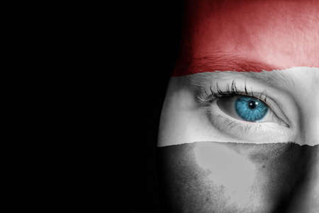 A young female with the flag of Yemen painted on her face on her way to a sporting event to show her support.の写真素材