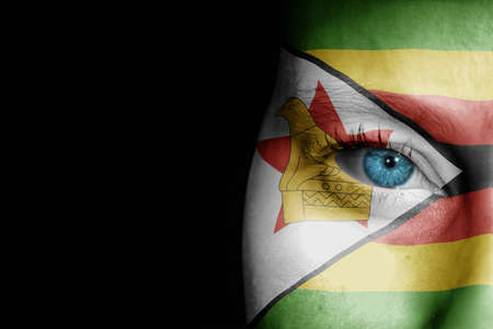 A young female with the flag of Zimbabwe painted on her face on her way to a sporting event to show her support.の写真素材