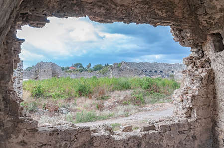 The ancient Roman amphitheatre situated in the turkish town of Side as seen from the nearby ancient hospital ruin.の写真素材