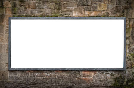 A blank billboard on a stone wall with space to place your own advertisingの写真素材