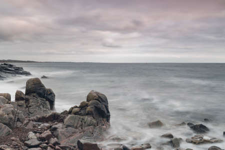 Rocky beach landscape at dusk. Kullaberg, Sweden.の写真素材