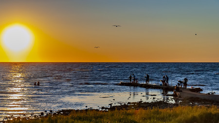 HELSINGBORG, SWEDEN - JULY 23, 2013: A group of people gather to watch the sunset at Helsingborg beach in Sweden.のeditorial素材