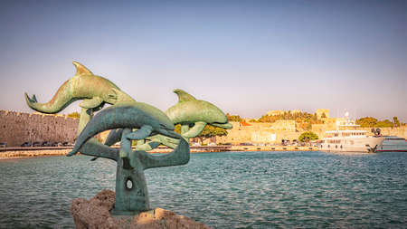 RHODES, GREECE - OCTOBER 06, 2018: The dolphin sculpture at Mandraki harbour.のeditorial素材